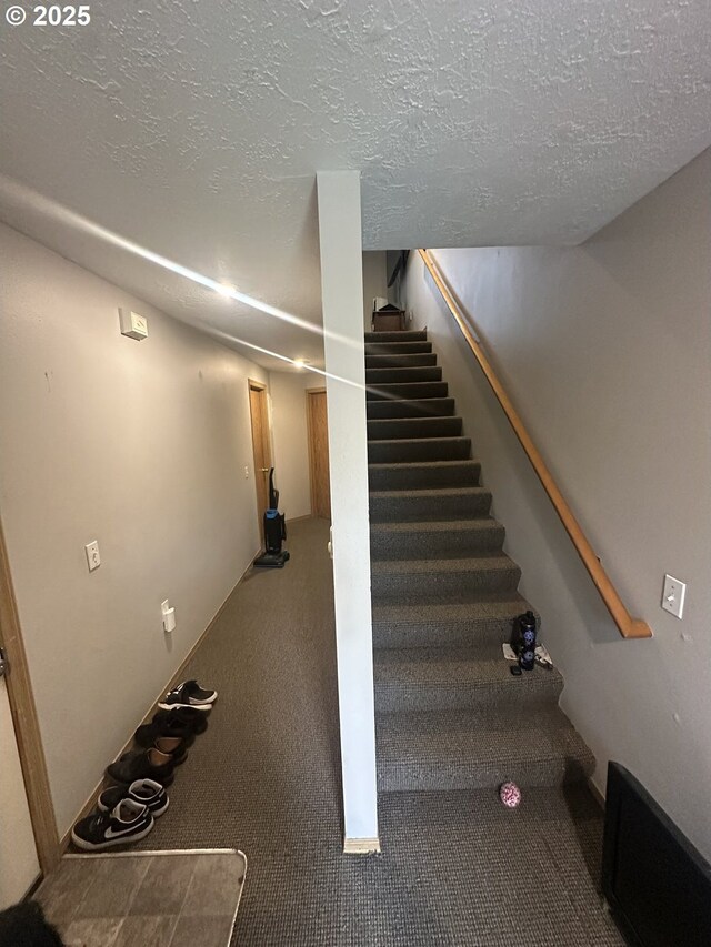 stairway featuring a textured ceiling