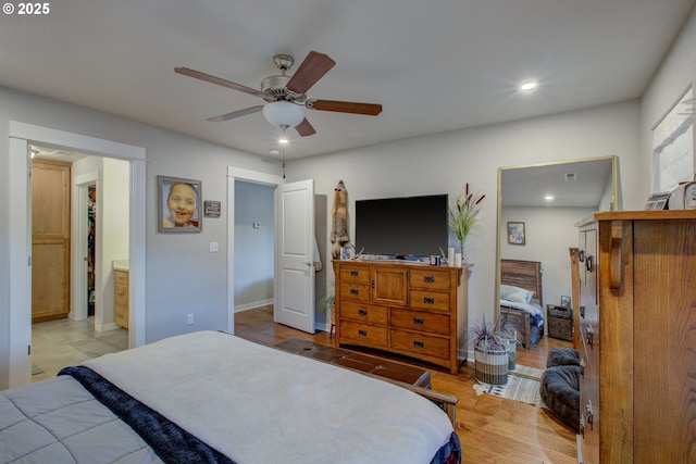 bedroom featuring connected bathroom, light hardwood / wood-style floors, and ceiling fan