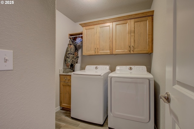 laundry room featuring a textured ceiling, cabinets, and washing machine and clothes dryer