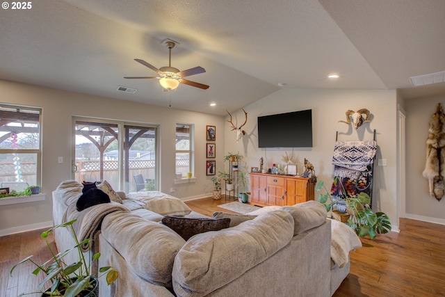 living room with vaulted ceiling, ceiling fan, and wood-type flooring