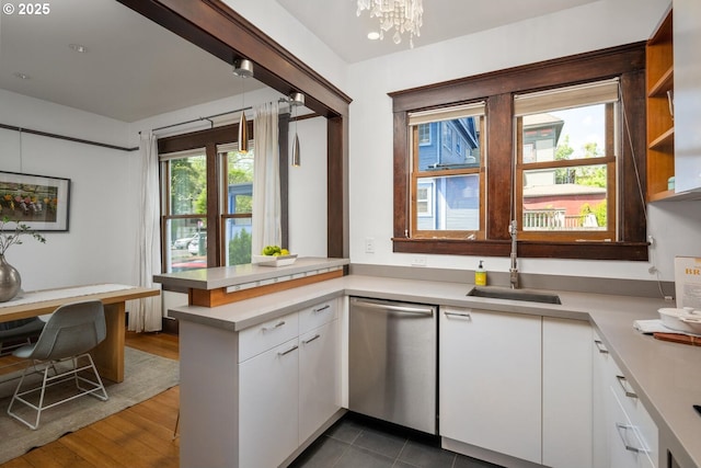 kitchen featuring dishwasher, a peninsula, white cabinets, and light countertops