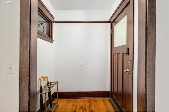 hall featuring wood finished floors and baseboards