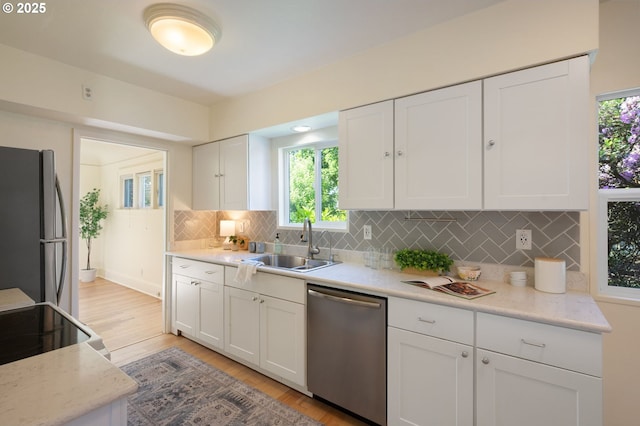 3636 NE 63rd Ave, Portland, OR 97213 - kitchen with appliances with stainless steel finishes, a sink, light wood-style floors, and white cabinets
