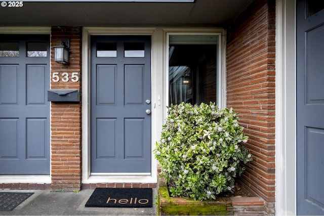 doorway to property featuring brick siding