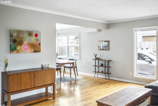 interior space with baseboards, wood finished floors, ornamental molding, and a wall mounted AC