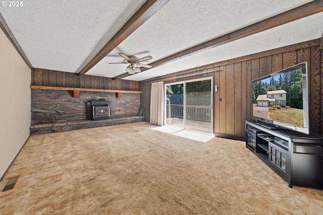 28410 S Beavercreek Rd, Mulino, OR 97042 - unfurnished living room with a wood stove, wooden walls, a textured ceiling, healthy amount of natural light, and beam ceiling