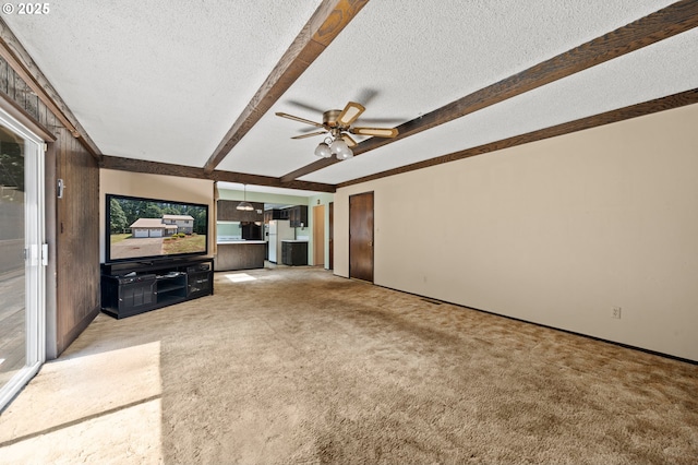 28410 S Beavercreek Rd, Mulino, OR 97042 - unfurnished living room with a textured ceiling, beamed ceiling, ceiling fan, and carpet
