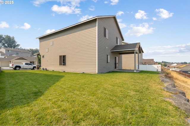 back of house with fence and a yard