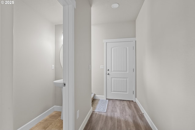 hallway featuring baseboards and wood finished floors
