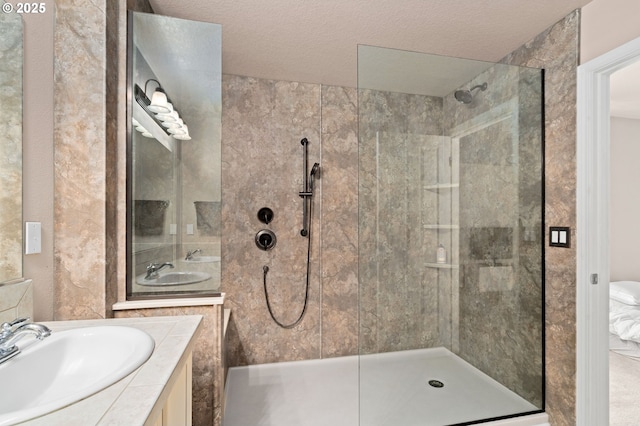bathroom featuring a shower stall, vanity, and a textured ceiling