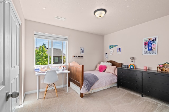 bedroom with carpet, a closet, an office area, and baseboards
