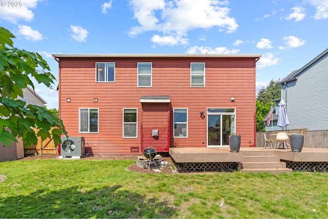 back of property with ac unit, a deck, and a lawn