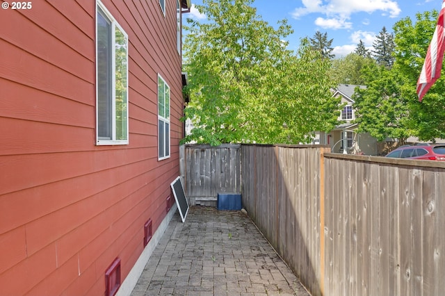 view of side of home with fence and a patio area