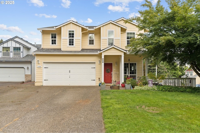 view of front of property with a front lawn, an attached garage, driveway, and roof with shingles