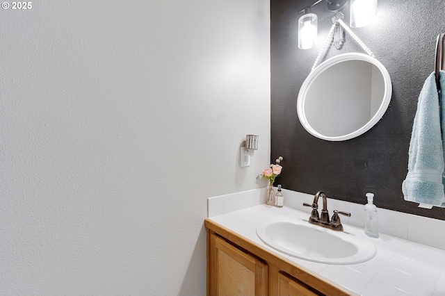 bathroom with vanity and a textured wall