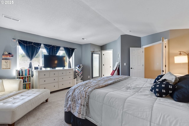 carpeted bedroom with visible vents, a textured ceiling, and vaulted ceiling