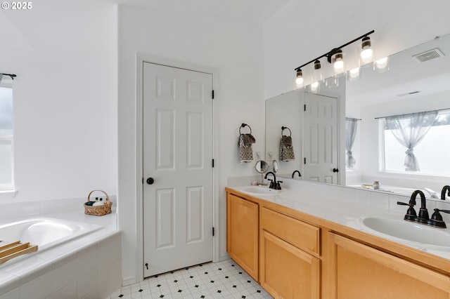 full bath featuring a sink, visible vents, a garden tub, and tile patterned floors