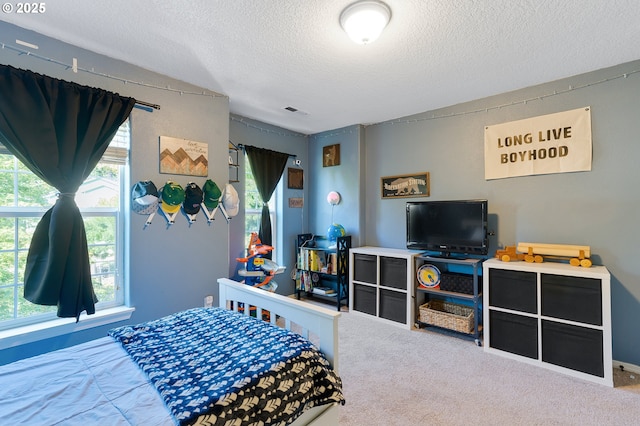 carpeted bedroom with visible vents and a textured ceiling