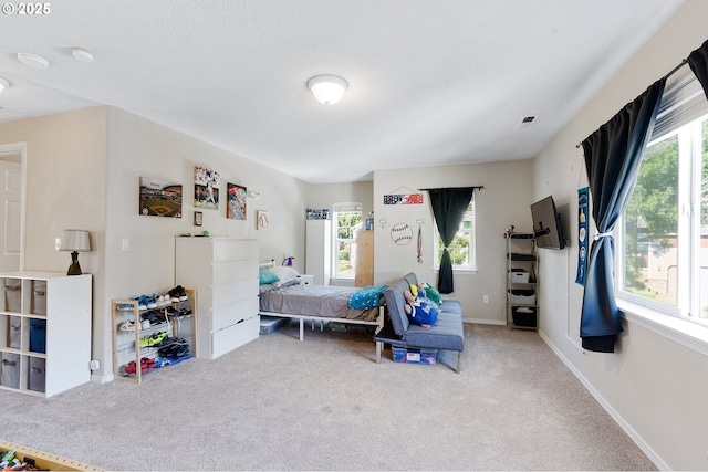 carpeted bedroom with baseboards, visible vents, and a textured ceiling