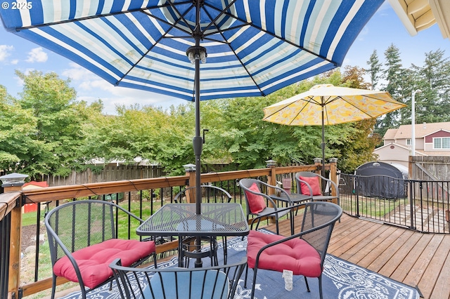 wooden terrace with outdoor dining space and fence