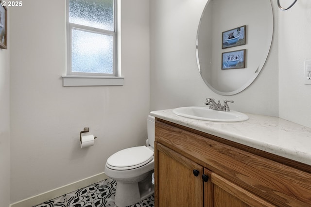 bathroom with toilet, vanity, and tile patterned floors