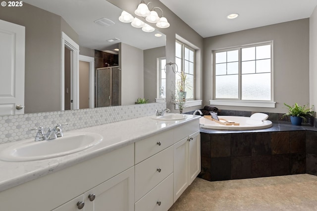 bathroom with tasteful backsplash, plus walk in shower, and vanity