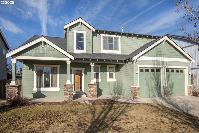 craftsman inspired home featuring a porch, a front yard, and a garage