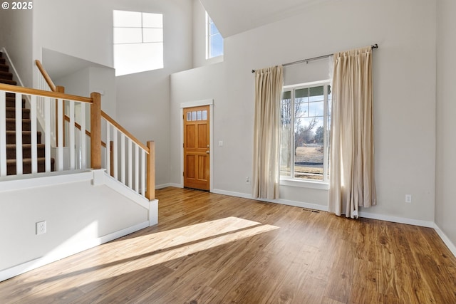 entryway featuring a high ceiling, plenty of natural light, and light hardwood / wood-style flooring