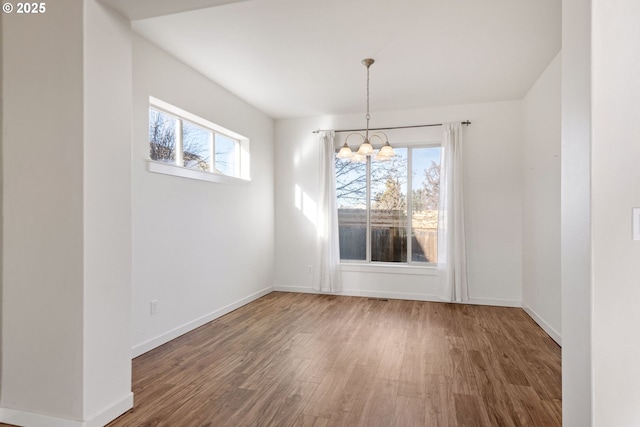 unfurnished dining area with a chandelier and hardwood / wood-style floors