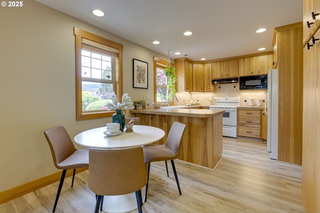 5818 SW Boundary St, Portland, OR 97221 - kitchen with white appliances, under cabinet range hood, a peninsula, light wood finished floors, and recessed lighting