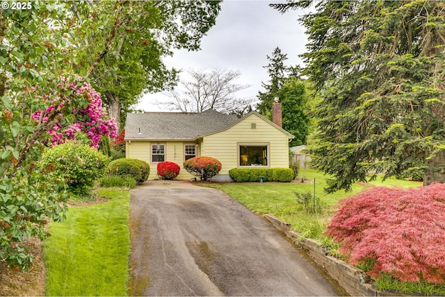 5818 SW Boundary St, Portland, OR 97221 - view of front of home featuring a chimney, a front lawn, and asphalt driveway