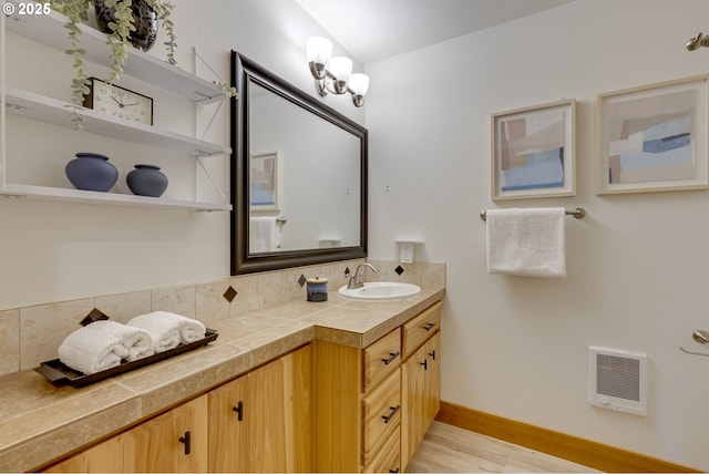5818 SW Boundary St, Portland, OR 97221 - bathroom with heating unit, vanity, wood finished floors, baseboards, and tasteful backsplash