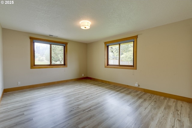 5818 SW Boundary St, Portland, OR 97221 - spare room featuring plenty of natural light, a textured ceiling, wood finished floors, and baseboards