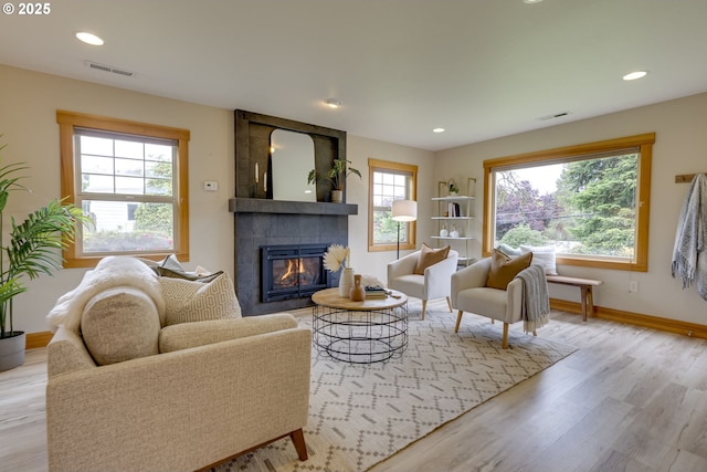 5818 SW Boundary St, Portland, OR 97221 - living room featuring a tiled fireplace, plenty of natural light, baseboards, wood finished floors, and recessed lighting