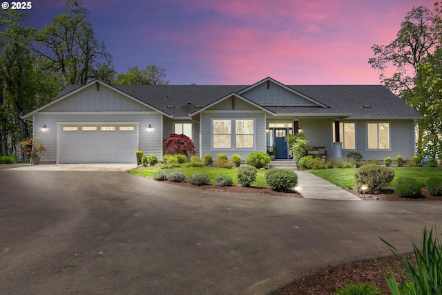 ranch-style home featuring a garage, board and batten siding, aphalt driveway, and a shingled roof