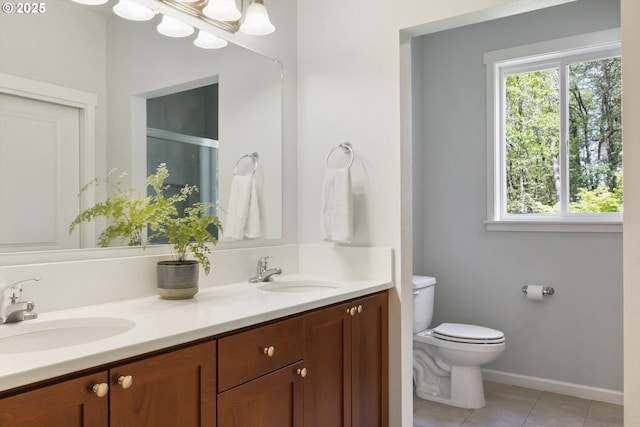 bathroom with a sink, tile patterned flooring, toilet, and double vanity