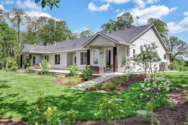 ranch-style house with a porch, a shingled roof, board and batten siding, and a front yard