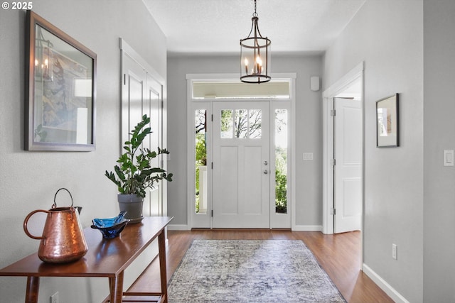 foyer entrance with baseboards and wood finished floors