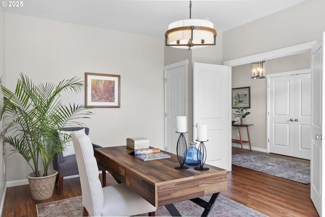 office featuring baseboards, a notable chandelier, and wood finished floors