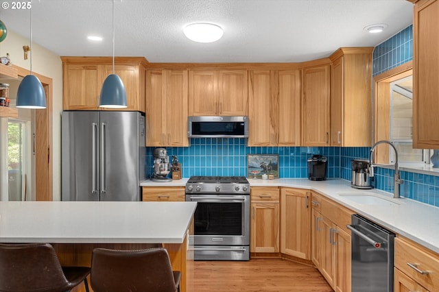 kitchen with a sink, light countertops, tasteful backsplash, and stainless steel appliances