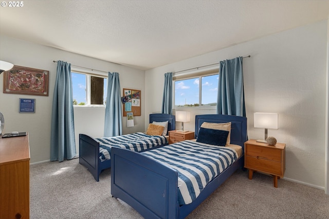 bedroom with a textured ceiling, baseboards, and light carpet