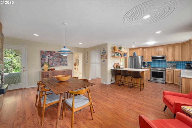 dining area with recessed lighting, baseboards, and light wood-type flooring
