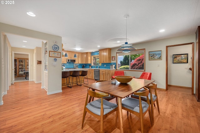 dining room with recessed lighting, baseboards, and light wood finished floors