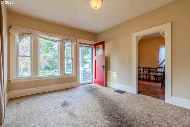 carpeted entryway with baseboards and visible vents