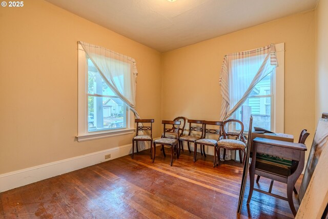 living area with baseboards and wood finished floors