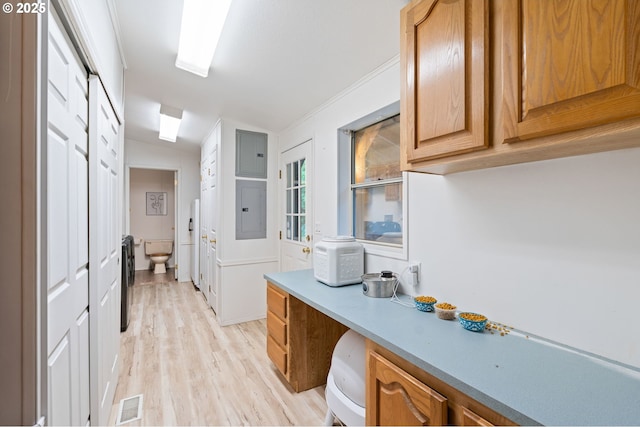 33385 Craig Loop, Cottage Grove, OR 97424 - kitchen with electric panel, lofted ceiling, light wood-style flooring, light countertops, and brown cabinets