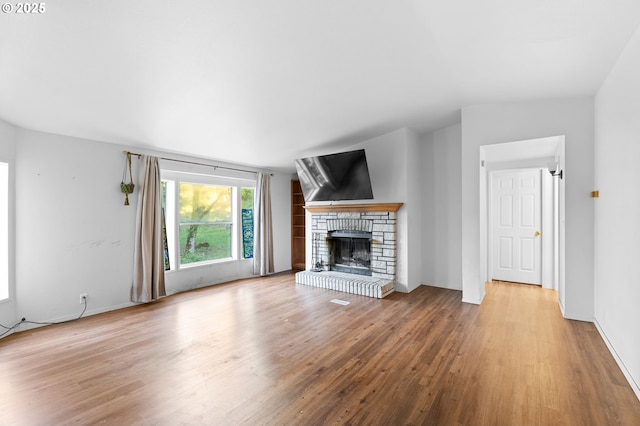33385 Craig Loop, Cottage Grove, OR 97424 - unfurnished living room with wood finished floors, a fireplace with raised hearth, and baseboards