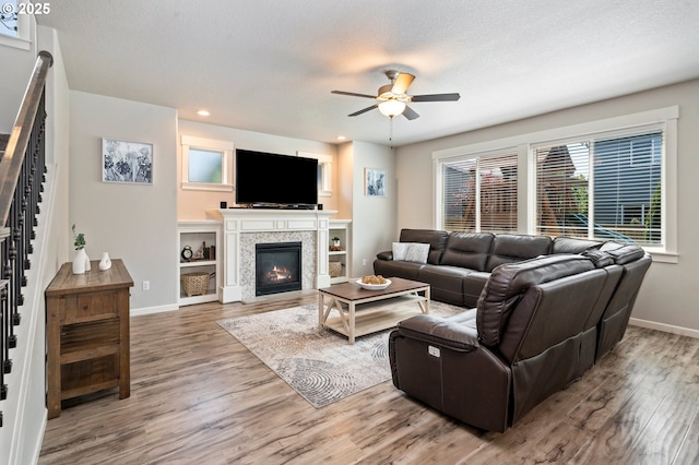 12209 Mimosa Way, Oregon City, OR 97045 - living room featuring baseboards, a ceiling fan, stairs, wood finished floors, and a glass covered fireplace