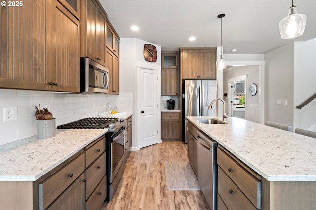 12209 Mimosa Way, Oregon City, OR 97045 - kitchen with appliances with stainless steel finishes, a sink, light wood finished floors, tasteful backsplash, and recessed lighting