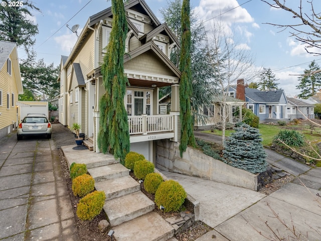 view of front of property featuring a garage, an outdoor structure, and a porch